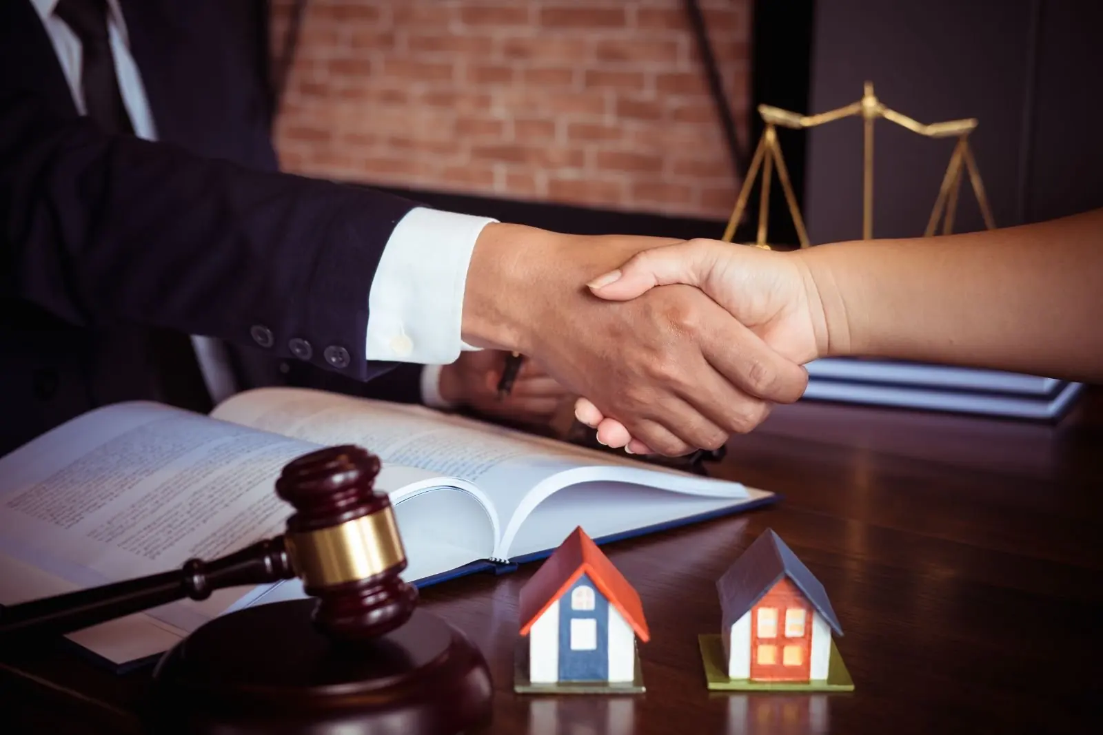 Handshake across a desk over signed documents